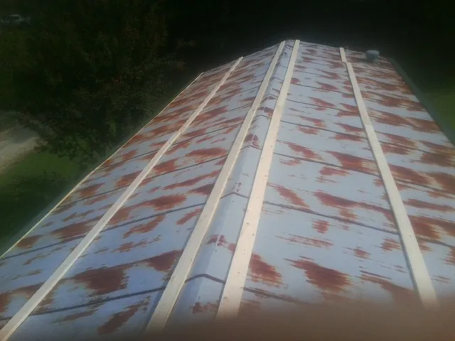 Rusted metal roof panels with new wood purlins before replacement — Storm Damage Roof Repair in Macon by Roofing Brothers